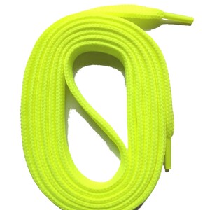 May include: Bright neon yellow shoelaces, coiled in an oval shape, against a white background. The laces have a woven texture and are designed for athletic shoes or sneakers. The aglets are a matching neon yellow.
