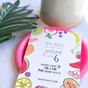 Puede incluir: Una invitaci&oacute;n colorida para una fiesta con tem&aacute;tica Tutti Fruitti para el sexto cumplea&ntilde;os de Jensen. La invitaci&oacute;n presenta una variedad de frutas, incluyendo sand&iacute;a, cerezas, limones y fresas. La fiesta es el s&aacute;bado 18 de agosto de 1:00 a 3:00 en 1940 Cascade Falls Ln. Se les pide a los invitados que traigan su traje de ba&ntilde;o para nadar.