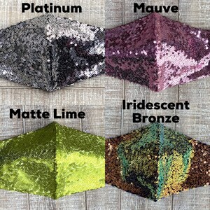 May include: Four different face masks made of sequins. The masks are in the colors platinum, mauve, matte lime, and iridescent bronze.