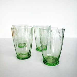 Könnte beinhalten: Set aus vier grünen Glas-Trinkgläsern mit einem geometrischen, geätzten Design.