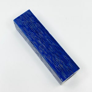 May include: A blue ceramic vase with a textured surface. The vase is rectangular in shape and has a narrow opening.