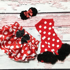Puede incluir: Falda de lunares rojos y blancos con un lazo negro, polainas de lunares rojos y blancos con ribete de encaje negro y una diadema con lazo rojo y negro.