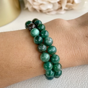 Könnte beinhalten: Ein grünes Edelstein-Armband mit runden Perlen. Das Armband besteht aus natürlichen Steinen und ist ein wunderschönes Accessoire für jeden Anlass.