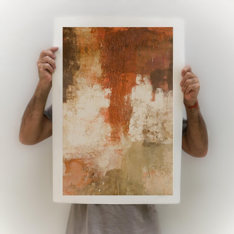 May include: A framed abstract painting with a textured surface. The painting features shades of brown, orange, and white.