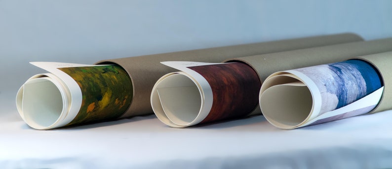 May include: Three rolled-up prints in brown cardboard tubes. The prints are visible on the ends of the tubes. The print on the left is a green and yellow landscape. The print in the middle is a red and brown landscape. The print on the right is a blue and white landscape.