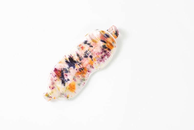 May include: A colorful sleep mask with a tie-dye pattern in shades of orange, yellow, purple, and blue.