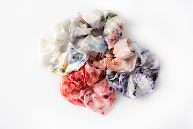 Puede incluir: Cinco scrunchies de tie-dye coloridos en una variedad de colores, incluyendo rosa, morado, azul y blanco.