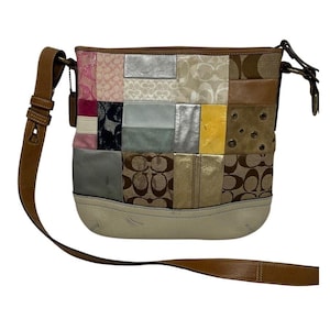 May include: A patchwork shoulder bag with a brown leather strap. The bag features a variety of textures and colours, including pink, silver, and brown. The bottom of the bag is a cream colour.