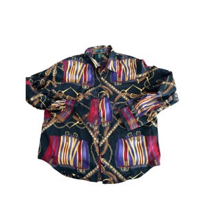 以下が含まれることがあります： カラフルな乗馬をテーマにしたプリントの黒いボタンダウンシャツ。パターンには、ゴールドのチェーン、茶色のベルト、赤、紫、ゴールドの縦縞模様が含まれています。 シャツは長袖で、襟が付いています。