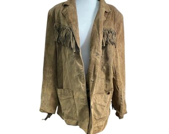 May include: A tan suede blazer with fringe detailing on the chest and sleeves. The jacket has a classic notched collar, button closure, and two front pockets. The blazer is a neutral color and has a vintage or bohemian style.
