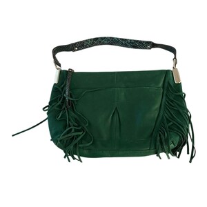May include: A green leather shoulder bag with fringe detailing. The bag features a snakeskin-patterned strap and silver-toned hardware. The bag has a suede-like texture and a pocket on the front.