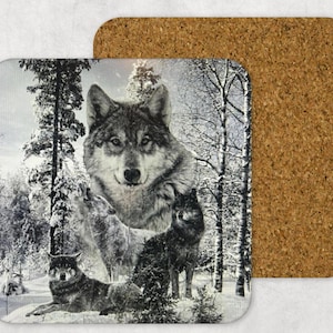 Può includere: Un sottobicchiere quadrato in sughero con un'immagine stampata di un lupo in una foresta innevata. Il lupo è al centro dell'immagine ed è circondato da alberi e neve.