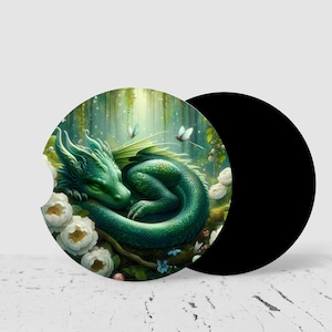 May include: A circular car coaster featuring a green dragon curled up among white flowers in a forest setting. The dragon has textured scales and closed eyes. The coaster has a small notch on the left side and a solid black back surface.
