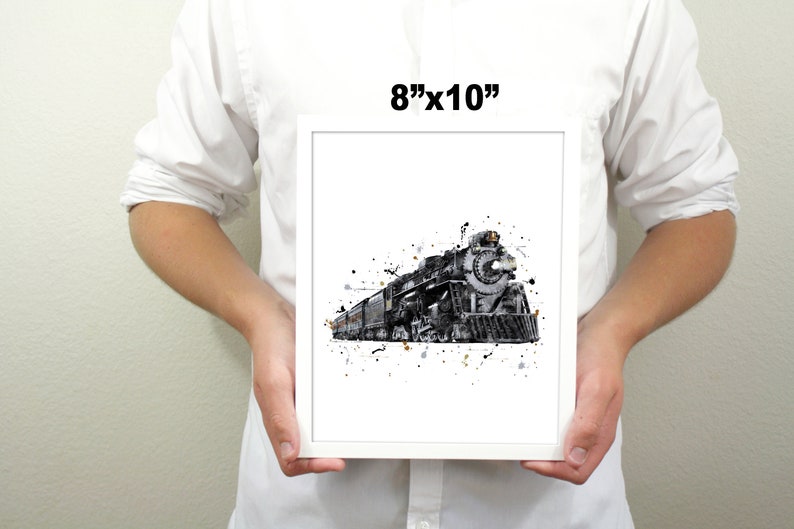 May include: A black and white watercolor print of a vintage steam locomotive train with a white background and black splatters. The print is framed and measures 8 inches by 10 inches.