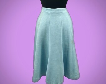May include: A light blue midi skirt with a simple, A-line silhouette. The skirt is made of a textured fabric and has a high waist.