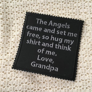 以下が含まれることがあります： 「The Angels came and set me free, so hug my shirt and think of me. Love, Grandpa」と白く刺繍された黒い布のパッチ。