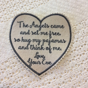 May include: A heart-shaped embroidered patch with the text "The Angels came and set me free, so hug my pajamas and think of me. Love, Your Eve."