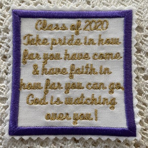 May include: A square white fabric patch with a purple border and gold embroidered text. The text reads "Class of 2020, Take pride in how far you have come & have faith in how far you can go, God is watching over you!"