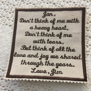May include: A beige fabric square with brown embroidered text that reads: "Jan., Don't think of me with a heavy heart. Don't think of me with tears. But think of all the love and joy we shared through the years. Love, Jim."