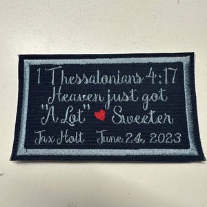 May include: A blue and white embroidered patch with the text "1 Thessalonians 4:17 Heaven just got "A Lot" Sweeter Jax Holt June 24, 2023".