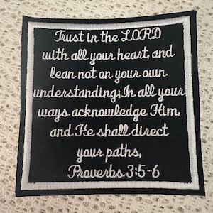 Pode incluir: Etiqueta bordada preta e branca com o texto "Trust in the LORD with all your heart, and lean not on your own understanding. In all your ways acknowledge Him, and He shall direct your paths, Proverbs 3:5-6".