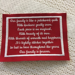 Könnte beinhalten: Roter Stoff-Patch mit weiß gesticktem Text, der lautet: "Unsere Familie ist wie ein Patchwork-Decken, Mit Freundlichkeit sanft zusammengenäht, Jedes Stück ist ein Original, Mit Schönheit seiner eigenen. Mit Fäden von Wärme und Glück Es ist fest zusammengenäht, Um in Liebe durch die Jahre zu halten Unsere Familie ist für immer."
