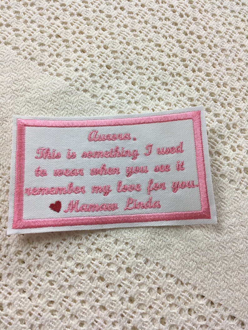 Pu&ograve; includere: Toppa ricamata rosa con un messaggio che dice "Aurora. This is something I used to wear when you see it remember my love for you. Mamaw Linda".