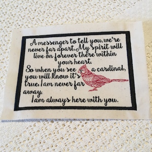 May include: A black framed embroidered design on a white background with a red cardinal bird and the text: "A messenger to tell you, we're never far apart. My Spirit will live on forever there within your heart. So when you see a cardinal, you will know it's true, I am never far away. I am always here with you."