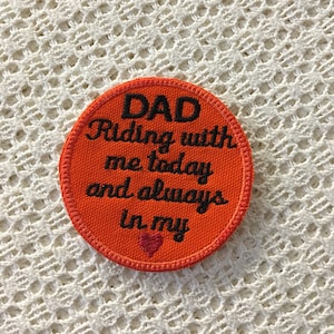以下が含まれることがあります： オレンジ色の丸い刺繍パッチで、黒い文字で「DAD Riding with me today and always in my」と書いてあり、小さな赤いハートが付いています。