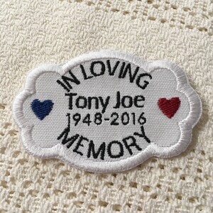 Può includere: Toppa ricamata bianca con bordo nero e il testo "In Loving Memory Tony Joe 1948-2016". Un cuore blu è a sinistra e un cuore rosso è a destra.
