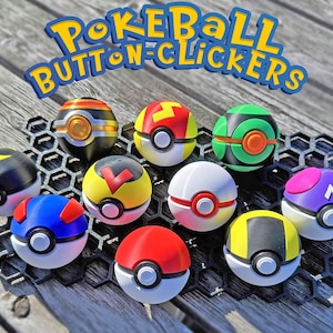 May include: A selection of colourful Pokéball Button Clickers, each with unique designs and colour schemes, including red, white, yellow, blue, and green. The text "PokeBall Button Clickers" is displayed above the items. They are arranged on a black honeycomb-patterned surface.