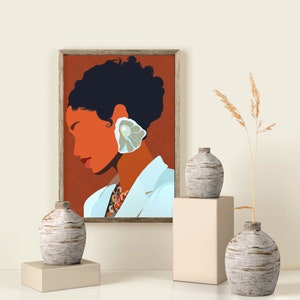 May include: An art print in a wooden frame depicts a woman with dark hair and an orange complexion, wearing a white jacket and a large, shell-shaped earring. The print is displayed with three textured, gray vases on pedestals, and a tall, dried plant.
