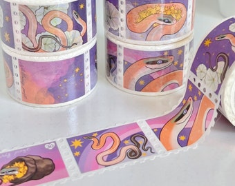Op de afbeelding: Een rol washi tape met een herhalend patroon van slangen, sterren en bloemen op een paarse achtergrond. De tape is gelabeld met "Stellar Fox".