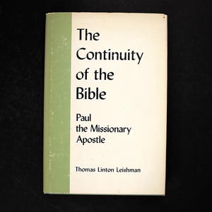 Op de afbeelding: Een boek getiteld The Continuity of the Bible: Paul the Missionary Apostle door Thomas Linton Leishman. De kaft heeft een crèmekleurige achtergrond met een verticale saliegroene streep aan de linkerkant en zwarte tekst op de voorzijde.