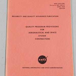 Puede incluir: Una publicación vintage de la NASA de color coral titulada "Publicación de Fiabilidad y Garantía de Calidad". El documento incluye el logotipo de la NASA y texto que detalla las disposiciones del programa de calidad para contratistas aeronáuticos y espaciales. La edición es de abril de 1969.