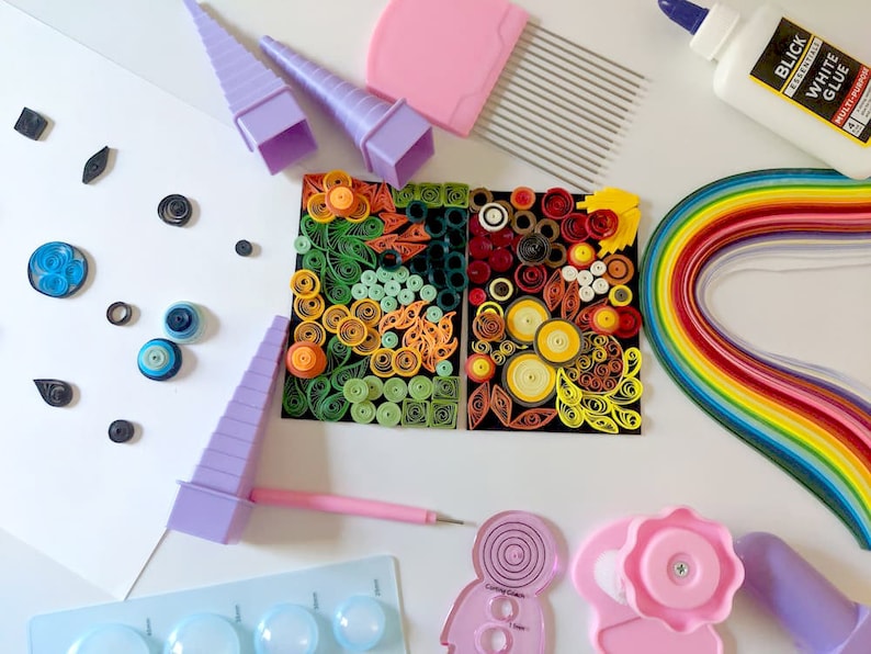 May include: A colourful assortment of paper quilling supplies, including a rainbow of paper strips, a glue bottle labelled "Blick White Glue", a set of quilling tools, and a finished quilling art piece.