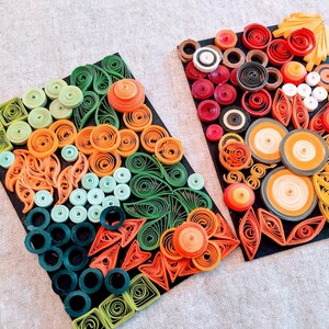 May include: Two framed pieces of paper art featuring colourful paper quilling designs. The designs are made up of circles, swirls, and other shapes in shades of green, orange, red, and yellow.