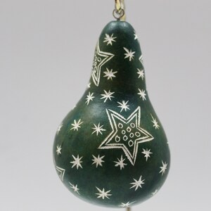 May include: A green gourd ornament with a white star pattern. The gourd is pear-shaped and has a loop at the top for hanging.