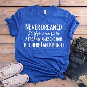 K&ouml;nnte beinhalten: Ein k&ouml;nigsblaues T-Shirt mit wei&szlig;em Text, der "NEVER DREAMED I'd grow up to be A FREAKIN' AWESOME MOM BUT HERE I AM, KILLIN' IT" lautet.
