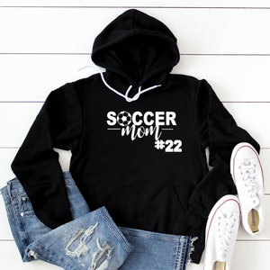 May include: Black hooded sweatshirt with white text that reads "SOCCER MOM #22" with a soccer ball graphic above the text.