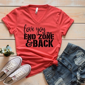 May include: Red V-neck t-shirt with the text "love you to the end zone & back" in black.