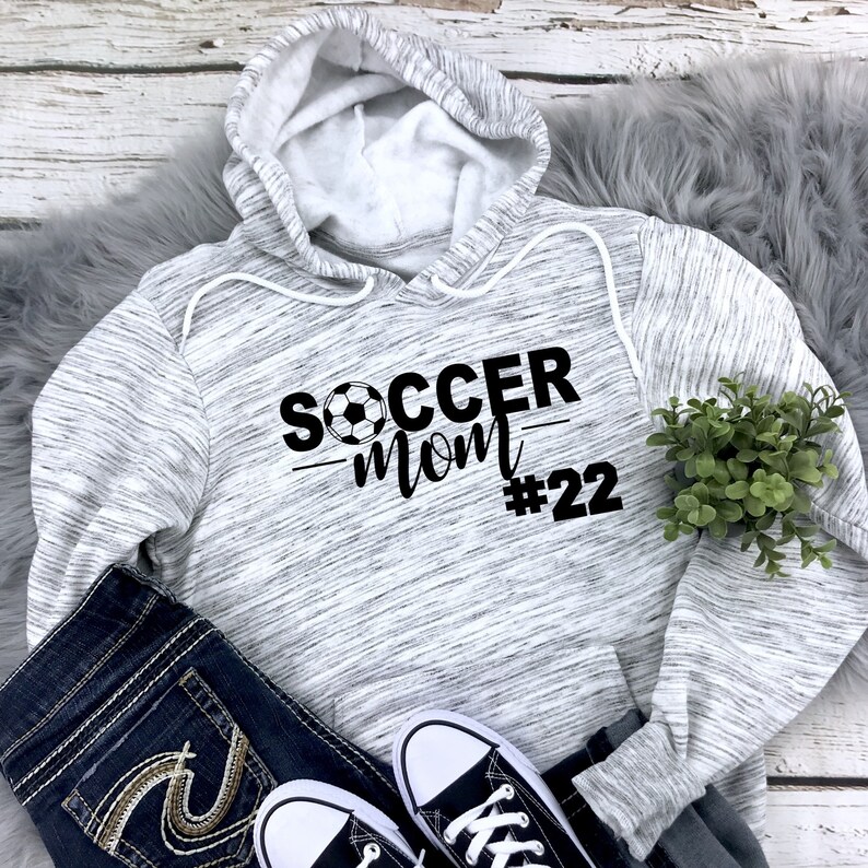 May include: Gray and white heather hoodie with black text that reads "Soccer Mom #22" with a soccer ball graphic.
