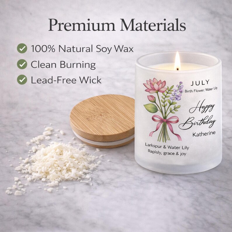 May include: A lit, frosted glass candle with a floral bouquet design and the text "Happy Birthday Katherine." The candle has a wooden lid and sits next to soy wax flakes. The text reads "100% Natural Soy Wax, Clean Burning, Lead-Free Wick."