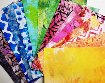Könnte beinhalten: Eine Sammlung von bunten gemusterten Papieren, darunter Blau, Grün, Gelb, Rot und Orange. Die Papiere sind fächerförmig angeordnet, wobei das gelbe Papier unten liegt.