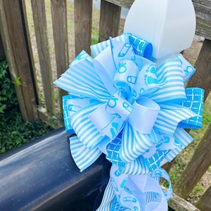 Lazo para bebé niño en celeste y blanco, con temática de niño y cinta con sonajero. Perfecto para buzón, puerta y corona.