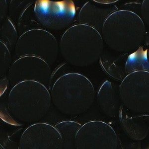 May include: A close-up of a pile of black round buttons with a slight iridescent sheen.
