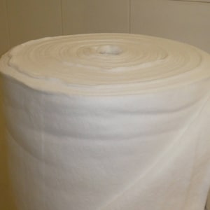 May include: A white, rolled up piece of batting, a soft, fluffy material used for quilting and crafts.