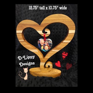 Könnte beinhalten: Ein herzförmiger Holzständer mit einem Foto von einem Mann und einem Mädchen darin. Der Ständer ist 32,4 cm hoch und 27,3 cm breit. Unten steht "D-Lippy Designs".