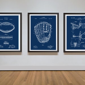 May include: Three framed vintage patent drawings on a white wall. The drawings are on a blue background and show a football, a baseball glove, and a basketball hoop. The text on the drawings includes the patent numbers and dates.