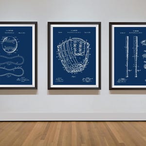 Pu&ograve; includere: Tre stampe incorniciate di brevetti di baseball. Le stampe presentano dettagliati disegni a tratteggio bianchi di una palla da baseball, un guanto da baseball e una mazza da baseball su sfondo blu scuro. Le cornici sono nere.